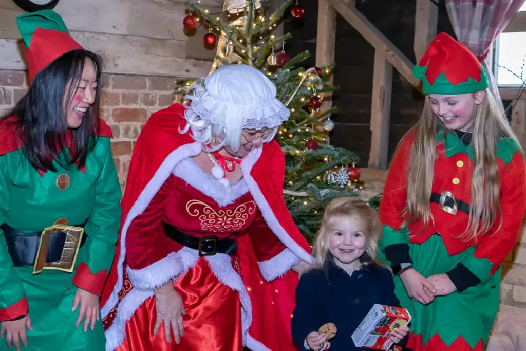 Small girl enjoys meeting mother christmas in her christmas grotto at lillingstone pick your own farm