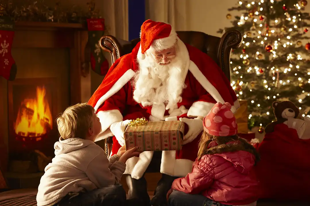 Santa clause gifts two young children a present at lillingstone pick your own farm