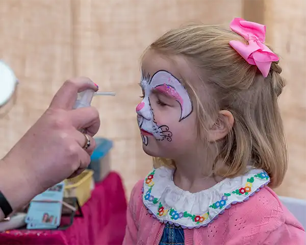 A young girl gets her face painted like a bunny rabbit at Lillingstone Pick Your Own easter events