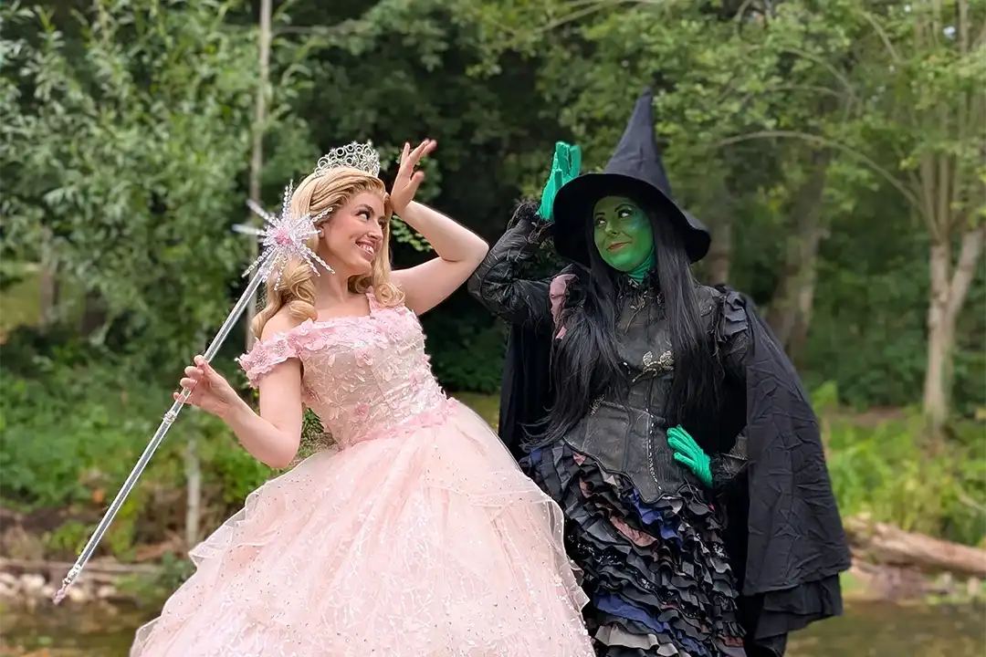 Glinda and Elphaba pose for a photo